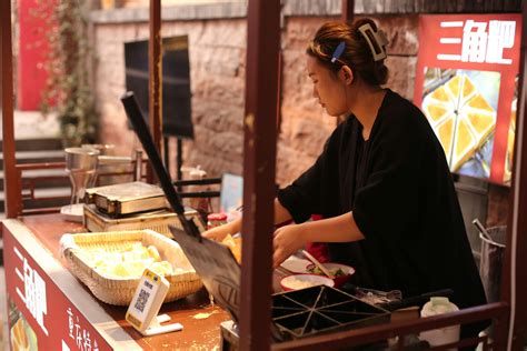 Mujer preparando y vendiendo sopaipillas en un puesto callejero