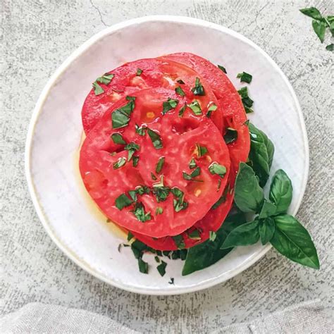 Disposición de ingredientes frescos para la preparación de una tarta de tomate y albahaca