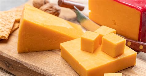 Fotografía de diferentes tipos de queso cheddar (bloques, ruedas, y variedades de color)