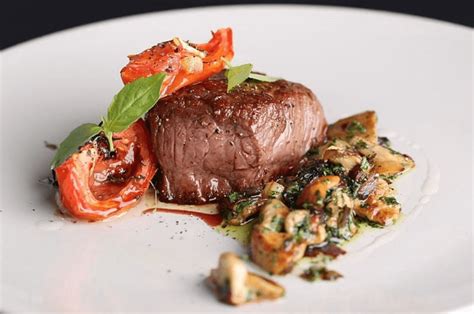 filete de res perfectamente cocinado cubierto con una brillante salsa de cerezas