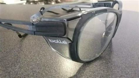 Fotografía de un trabajador utilizando gafas Bollé Aka en un entorno exterior soleado, con las lentes visiblemente oscurecidas.