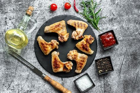 Manos masajeando un pollo con aceite de oliva