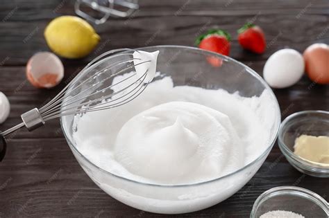 Primer plano de claras de huevo siendo batidas en un bol hasta obtener una espuma blanca y esponjosa.