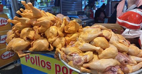 Mercado de alimentos en Bolivia con puesto de venta de pollo y controles de sanidad