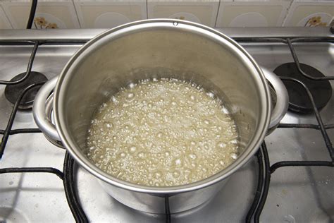 Proceso de vertido del almíbar sobre las yemas batidas