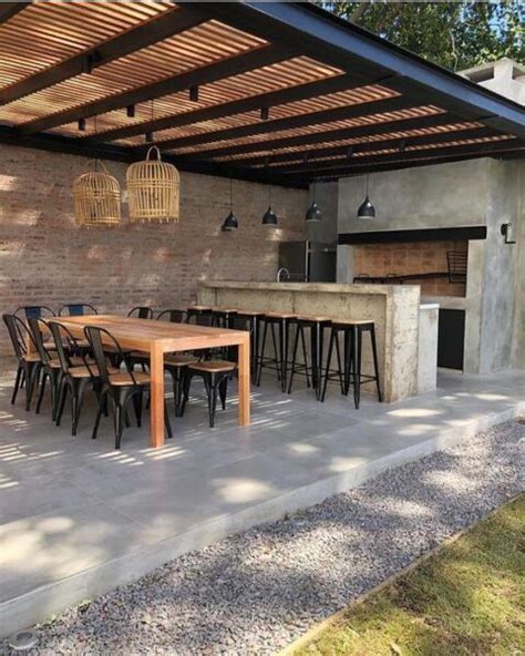 Vista panorámica de un quincho moderno con parrilla integrada y mobiliario de exterior