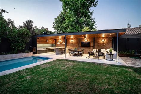 Detalle de un quincho moderno integrado a un jardín con piscina