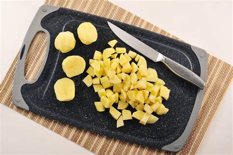 patatas cortadas en cubos en un bol con especias y harina de garbanzo