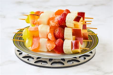 Variedad de brochetas de frutas coloridas en un plato