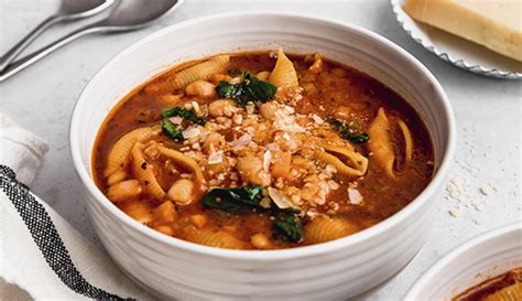 Mesa con ingredientes frescos para menestrón: porotos, verduras picadas, pasta