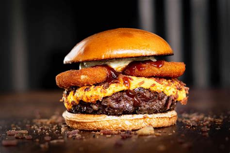 Hamburguesa de carne gourmet con aros de cebolla caseros y papas fritas