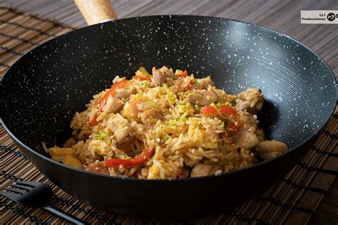Primer plano de un wok humeante con Arroz Chaufa en preparación.
