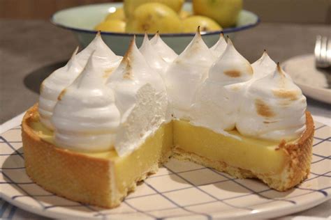 Foto de una porción de lemon pie acompañada de una bebida cítrica