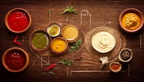 Fotografía de una tabla de carnes acompañadas por diversos cuencos con salsas artesanales a base de mayonesa.