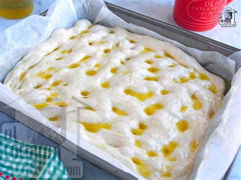 masa de focaccia extendida en bandeja de horno lista para la segunda fermentación