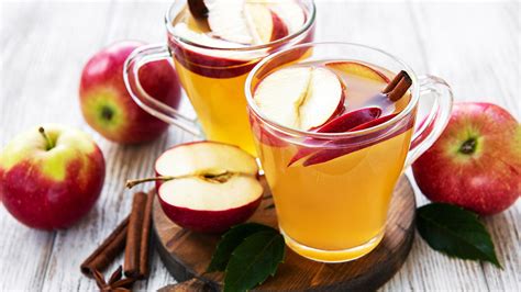 Persona bebiendo una taza de infusión de manzana y canela por la mañana