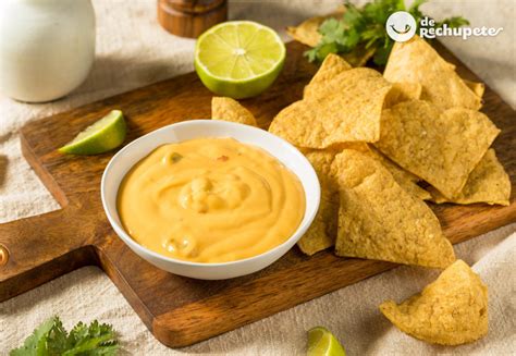 Foto de salsa de queso cheddar cremosa en un bol con nachos