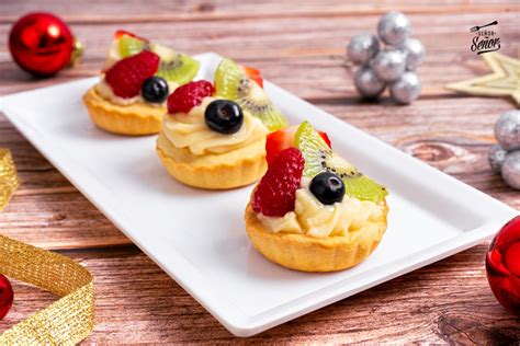 Surtido de postres rellenos de crema pastelera, como éclairs y tartaletas de frutas