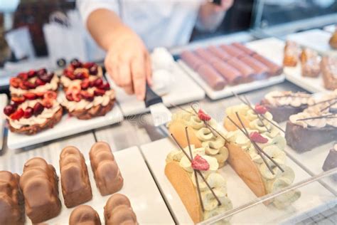 Fotografía: Un expositor de pastelería con postres decorados con frutas frescas