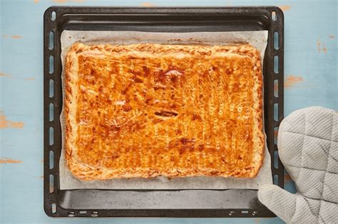 Empanada gallega recién horneada y dorada en bandeja de horno.