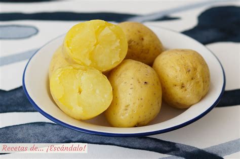 Mano pinchando una patata cocida con un tenedor para comprobar su cocción