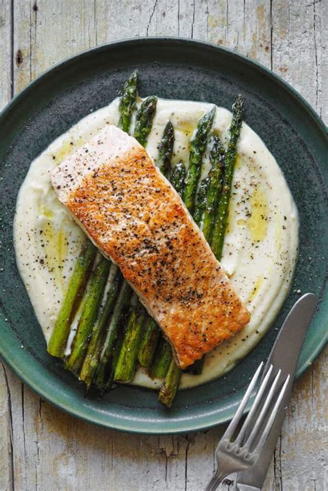 Salmón frito emplatado con puré de papas y espárragos