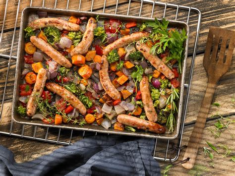 Esquema de un horno con salchichas y vegetales asándose
