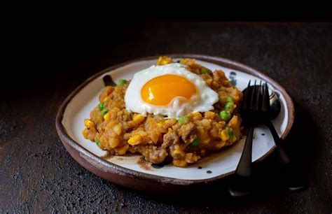 Foto de un plato de charquicán chileno servido con huevo frito y ensalada