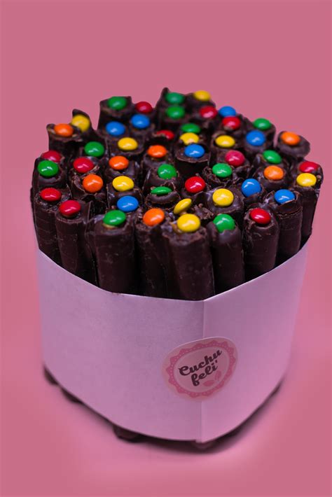 Fotografía de una torta de cuchuflí vegana decorada con chocolates de colores