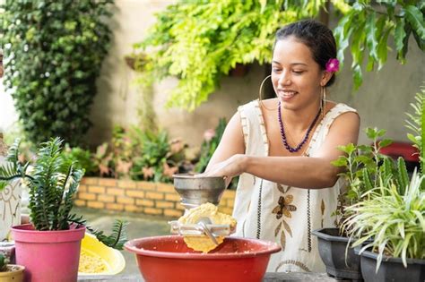 Mujer otomí moliendo maíz en un metate.
