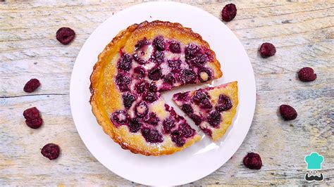 Fotografía cenital de un kuchen de frambuesa recién horneado sobre una mesa de madera rústica.