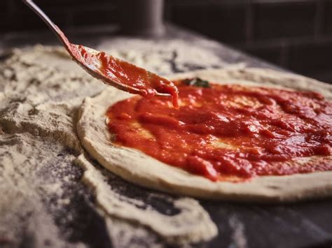 Pizza con salsa de tomate y queso mozzarella, lista para hornear