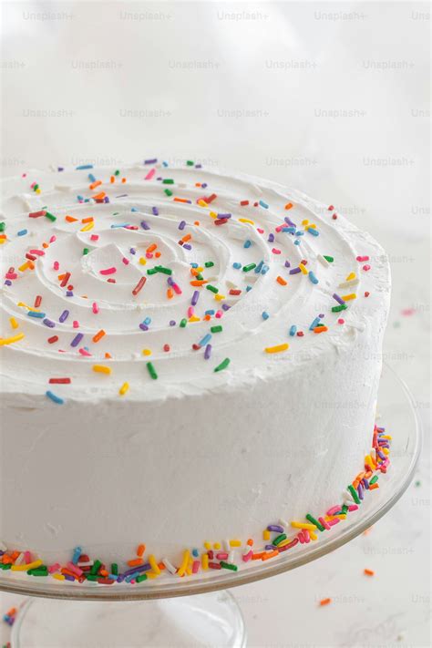 Un pastel decorado con un glaseado blanco sencillo y unas pocas flores comestibles.