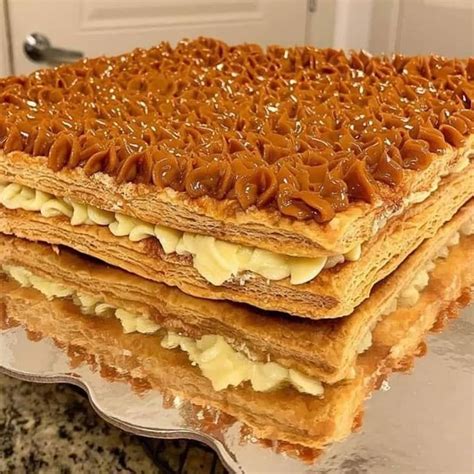 Torta milhoja recién preparada y decorada, con capas visibles de masa crocante y un generoso relleno de manjar.