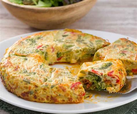fotografía de una tortilla de verduras recién hecha, con un corte que muestra el interior