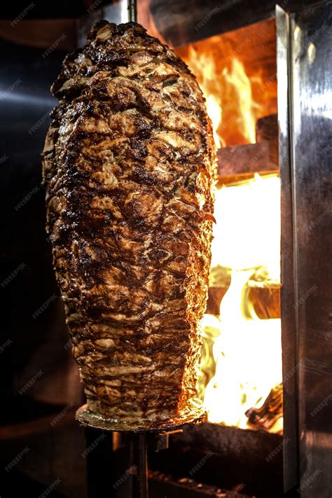 Fotografía de pinchos de carne de shawarma cocinándose a la parrilla.