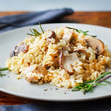 Fotografía profesional de un plato de arroz con hongos servido con hierbas frescas y un toque de queso rallado.