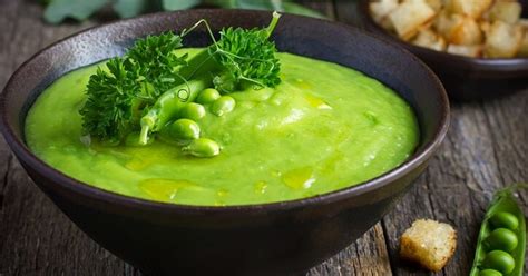 Tazón de sopa de crema de arvejas con guarnición fresca