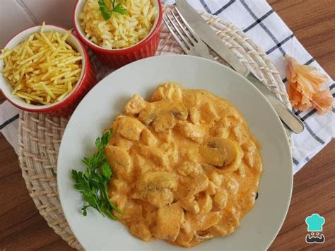 Strogonoff de pollo brasileño servido con arroz y patatas paja