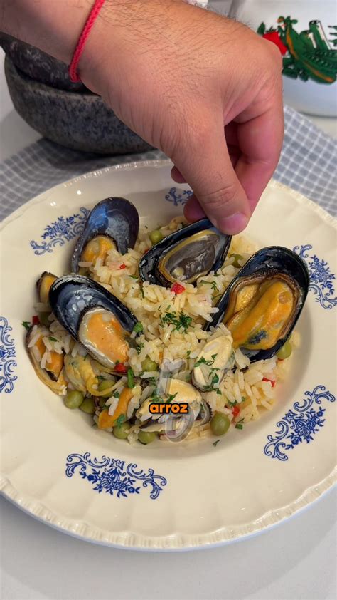 Fotografía de una olla humeante con pollo, choritos, camarones y una salsa cremosa