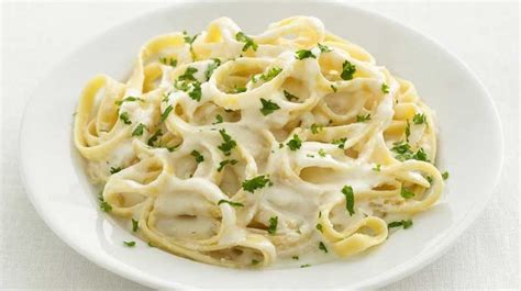 Plato de pasta fettuccine con salsa Alfredo y perejil fresco