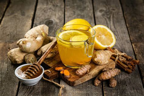 Varias tazas de infusiones de cúrcuma con jengibre, limón y miel