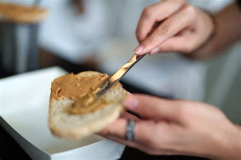Temático: Manos extendiendo mantequilla de maní en una tostada