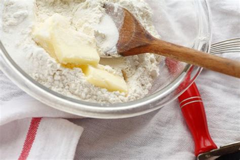 Primer plano de la mezcla de harina y mantequilla, mostrando una textura arenosa con grumos.