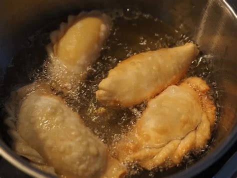 Empanadas friéndose en aceite caliente hasta dorarse