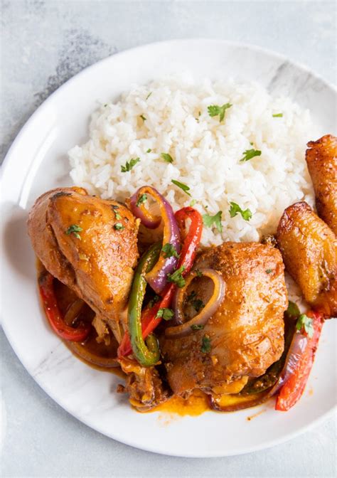 Plato de pollo a la cerveza guisado servido con arroz blanco y pan