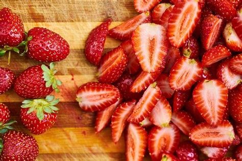 Fotografía de fresas troceadas organizadas en una sola capa sobre una bandeja antes de ser introducidas al congelador