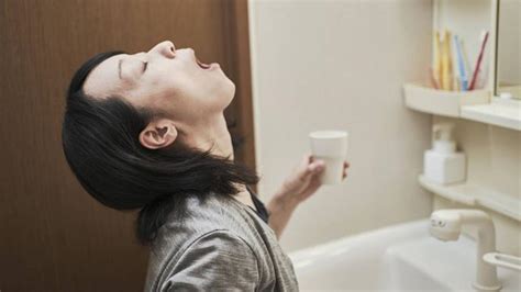 Ilustración mostrando a una persona realizando gárgaras con agua salada y utilizando hilo dental como parte de su rutina de higiene bucal.