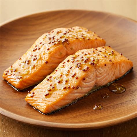 Filetes de salmón glaseados con miel y ajo, servidos con rodajas de limón.