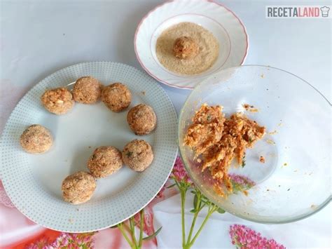 Manos formando albóndigas y rebozándolas en pan rallado